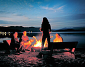 USA, Idaho, family around a beach bonfire, Priest Lake