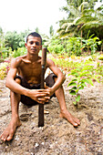 INDONESIA, Mentawai Islands, Kandui Surf Resort, portrait of young man holding a machete