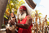 MAURITIUS, a local woodcarver works on a carving by the waterfront in Port Louis