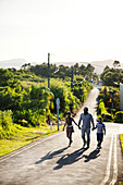 MAURITIUS, a family nears the top of a long road to have a look into Troux aux Cerfs crater, the town of Curepipe