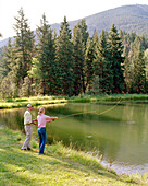 USA, Montana, woman fly fishing for trout in a lake, Mountain Sky Guest Ranch