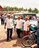 PANAMA, El Valle, taxi drivers stand in a parking lot in front of an open air farmers market