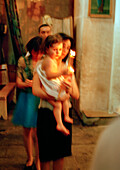 REPUBLIC OF GEORGIA, mother carrying her child and candles at a traditional baptism, Tbilisi