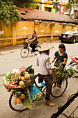 VIETNAM, Hanoi, a street vendor sells pineapples, limes and other produce from her bicycle