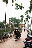VIETNAM, Hanoi, two people on a moped look for a place to park, Tran Quoc Pagoda