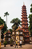 VIETNAM, Hanoi, a young couple walk around the Tran Quoc Pagota located at Hoan Kiem Lake