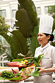 VIETNAM, Hanoi, Sofitel Metropole Hotel, chef Kim Hai holds a tray filled with lunch selections