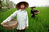 VIETNAM, Hanoi countryside, rice farmers Nguyen Huu Uc and Nguyen Thi Ha spread seed in their family rice field, Nguyen Huu Y village