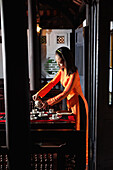VIETNAM, Hue, Ms. Boi Tran's Hoang Vien restaurant, a woman in traditional dress pours tea