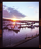 USA, Washington State, Seattle, a view of fishing boats and the sun setting from the Freemont Bridge