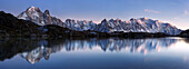 Panorama of the Mont Blanc massif at dusk with reflection in the mountain lake Lac de Chesery in Autumn, Chamonix Valley, Haute-Savoie, France