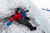Children playing in the ice at the river Elbe, Hamburg, Germany