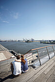 Couple on the terrace of Dockland,  office building, near Altona fishing harbour, Hamburg, Germany