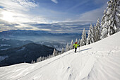 Skitourgeherin steigt zum Kranzhorn auf, Kaisergebirge im Hintergrund, Chiemgauer Alpen, Tirol, Österreich