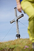 Gipfelkreuz mit Edelweiß, Wanderin im Vordergrund, Alpe-Adria-Trail, Nockberge, Kärnten, Österreich