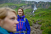 Two female hikers, waterfall in background, Nockberge, Carinthia, Austria
