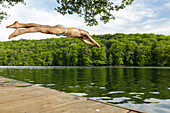 Man jumping into lake Schmaler Luzin, Feldberger Seenlandschaft, Mecklenburg-Western Pomerania, Germany