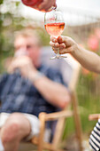 Woman pouring glass of wine outdoors