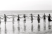 Woman Running on Beach Holding Hands