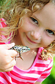 Little girl smiling and holding a frog, Simcoe, Ontario