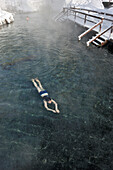 A young girl swimming in hot springs in mid winter, Liard River Hot Springs, Northern British Columbia