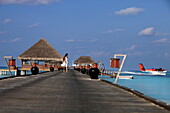 Republic of the Maldives, Lhaviyani Atoll,  Kanuhura Hotel, woman walking on the landing stage