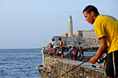 Fishermen at the Malecon in La Havana with Castillo del Morro in the background, Cuba