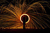 Man Spinning Ball Of Burning Steel Wool At Night, Petersfield, Hampshire, Uk