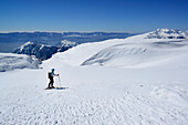 Female backcountry skier ascending over large plateau to Monte Sirente, Abruzzo, Italy