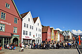 Persons sitting in a cafe, Hanseatic buildings in the background, Bryggen, UNESCO World Heritage Site Bryggen, Bergen, Hordaland, Norway