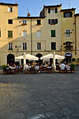 Häuser und Restaurant an der ovalen Piazza dell'Anfitheatro, Lucca, Toskana, Italien