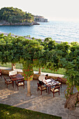 Waiter setting a table on terrace of Villa Milocer, Aman Sveti Stefan, Sveti Stefan, Budva, Montenegro