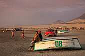 People enjoying the sunset on the beach with cars and fishing boats, Salaverry near Trujillo, La Libertad, Peru