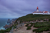 Leuchtturm Cabo da Roja an der Atlantikküste (der westlichste Punkt von Kontinentaleuropa) im Dämmerlicht, nahe Cascais, Estremadura, Portugal
