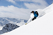 Man downhill skiing in deep snow, Davos, Grisons, Switzerland