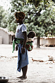 Girl carrying a baby on back, Magadala, Mali