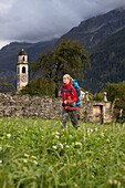 Young woman with backpack hiking, Soglio, Bergell, Canton of Grisons, Switzerland