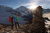 Hikers looking at view in Val Bernina, Piz Palu and Pers Glacier in background, Engadin, Canto of Grisons, Switzerland
