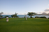 Golfer putting on the Green of Hole 11: Round the Bend at Le Touessrok Golf Course, Ile aux Cerfs Island, near Trou d'Eau Douce, Flacq District, Mauritius