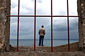 Man looking out over the Straits of Gibraltar from the Borj Dar el-Baroud, Tangiers, Morocco