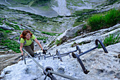 Frau steigt über Eisenkrampen zur Zugspitze auf, Höllental, Wettersteingebirge, Oberbayern, Bayern, Deutschland