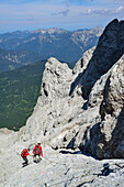 Two mountaineers descending on fixed rope route to Wiener-Neustaedter hut, Zugspitze, Wetterstein range, Upper Bavaria, Bavaria, Germany