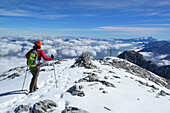 Woman descending from Hoher Goell, Dachstein range in background, Berchtesgaden National Park, Berchtesgaden Alps, Upper Bavaria, Bavaria, Germany