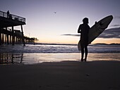Surfer on the beach in pismo Beach, California