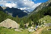 Hiker walking along Barrosa valley, a typical glacier valley of aragonese Pyrenees  Huesca  Spain
