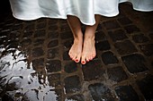 Bride´s bare feet on wet san pietrini stones in Rome Italy