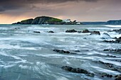 Rocky shores of Bantham at Dusk view towards Burgh Island, Devon, England, UK, Europe
