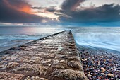 Waves rushing over the breakwater alongside beach in Dawlish, Devon, England, United Kingdom, Europe