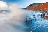 Waves crashing against walkway in Sidmouth, Devon, England, United Kingdom, Europe