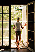 Teenage Girl Standin in Doorway Looking Outside, Rear View